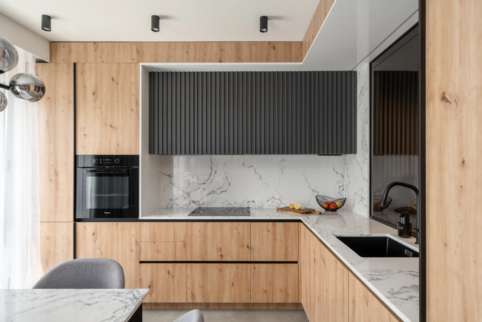 PHOBIA — custom kitchen with timber cabinetry, dark fluted fronts and stone surfaces