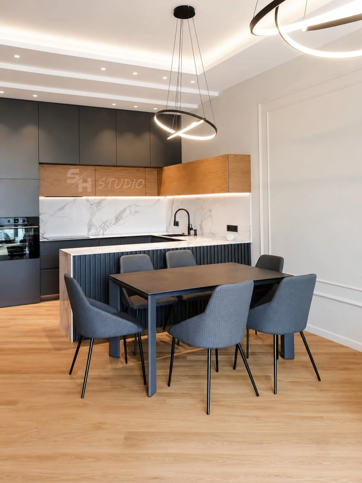 MMK Residence — kitchen with oak-veneered upper cabinets and dining area