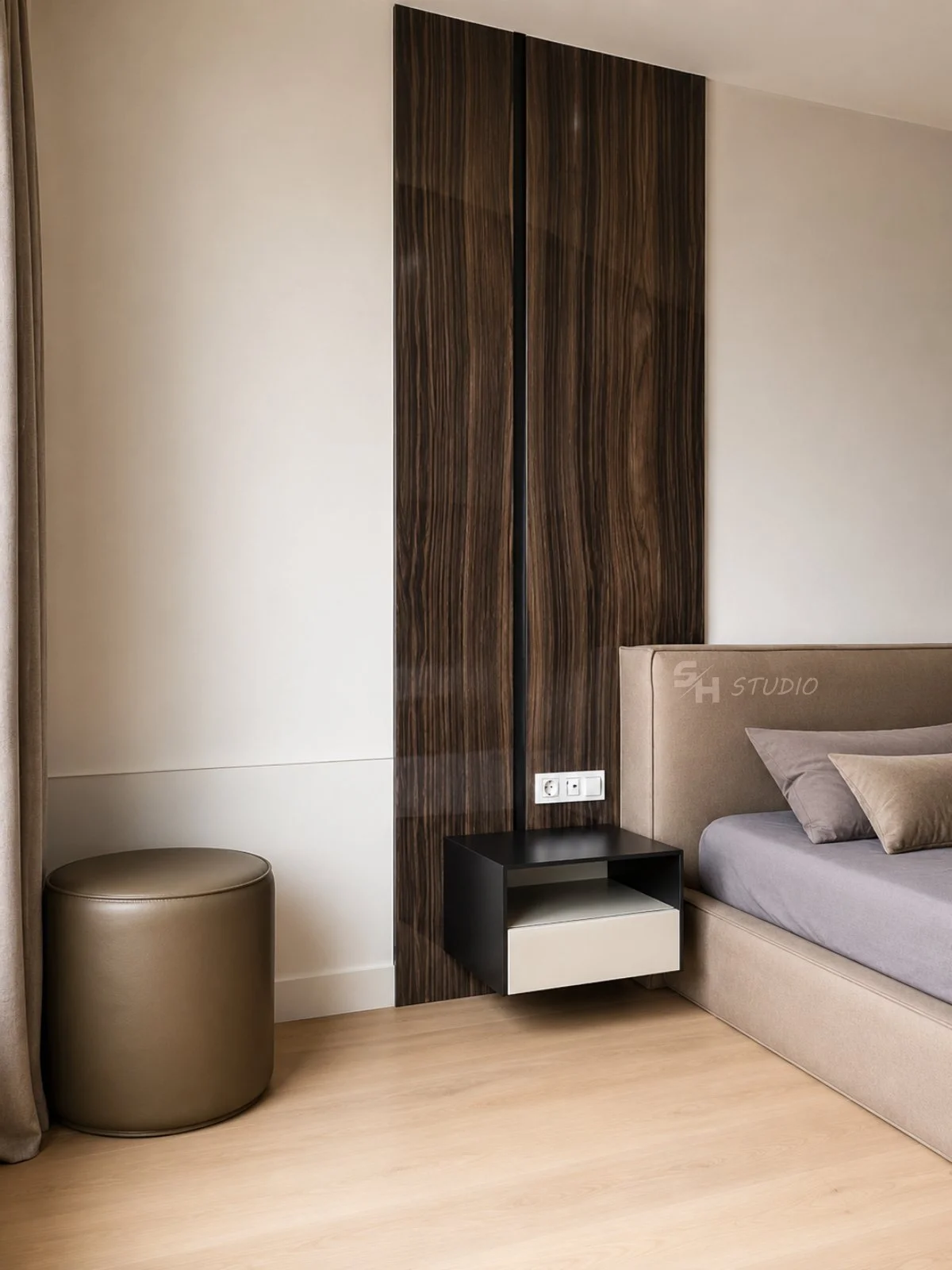 PSNG — bedroom detail with walnut-veneered full-height panel, leather pouf and floating bedside drawer