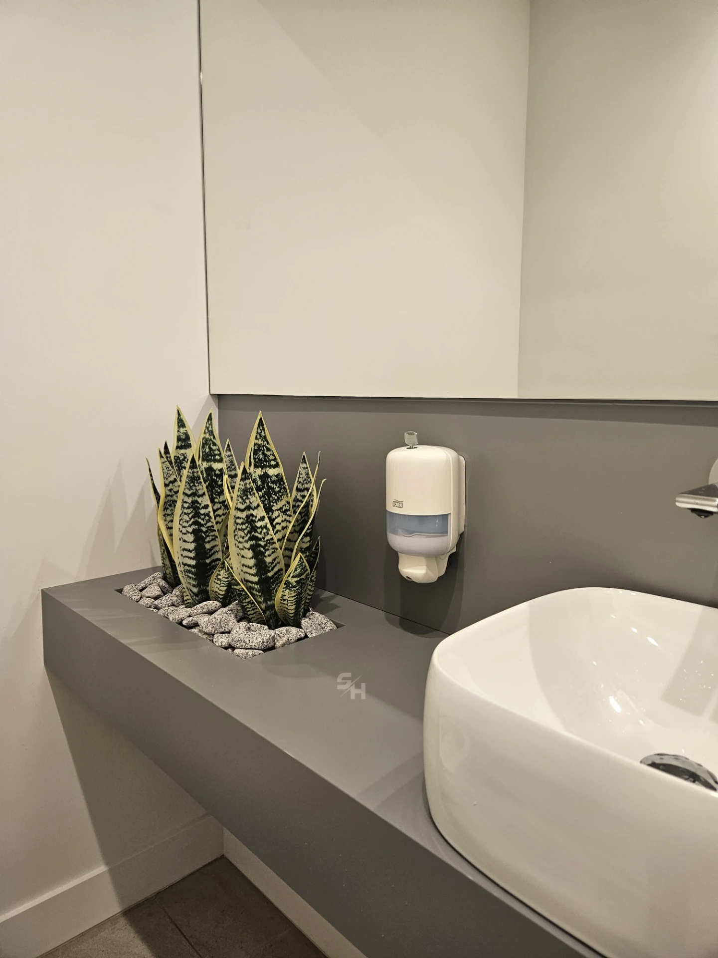VDR Office — WC lobby with cantilevered waterproof PVC sink counter and mirrored wall