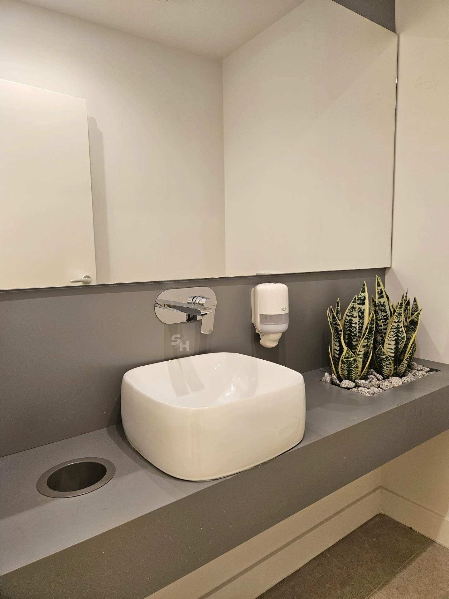 VDR Office — WC lobby with cantilevered waterproof PVC sink counter and mirrored wall
