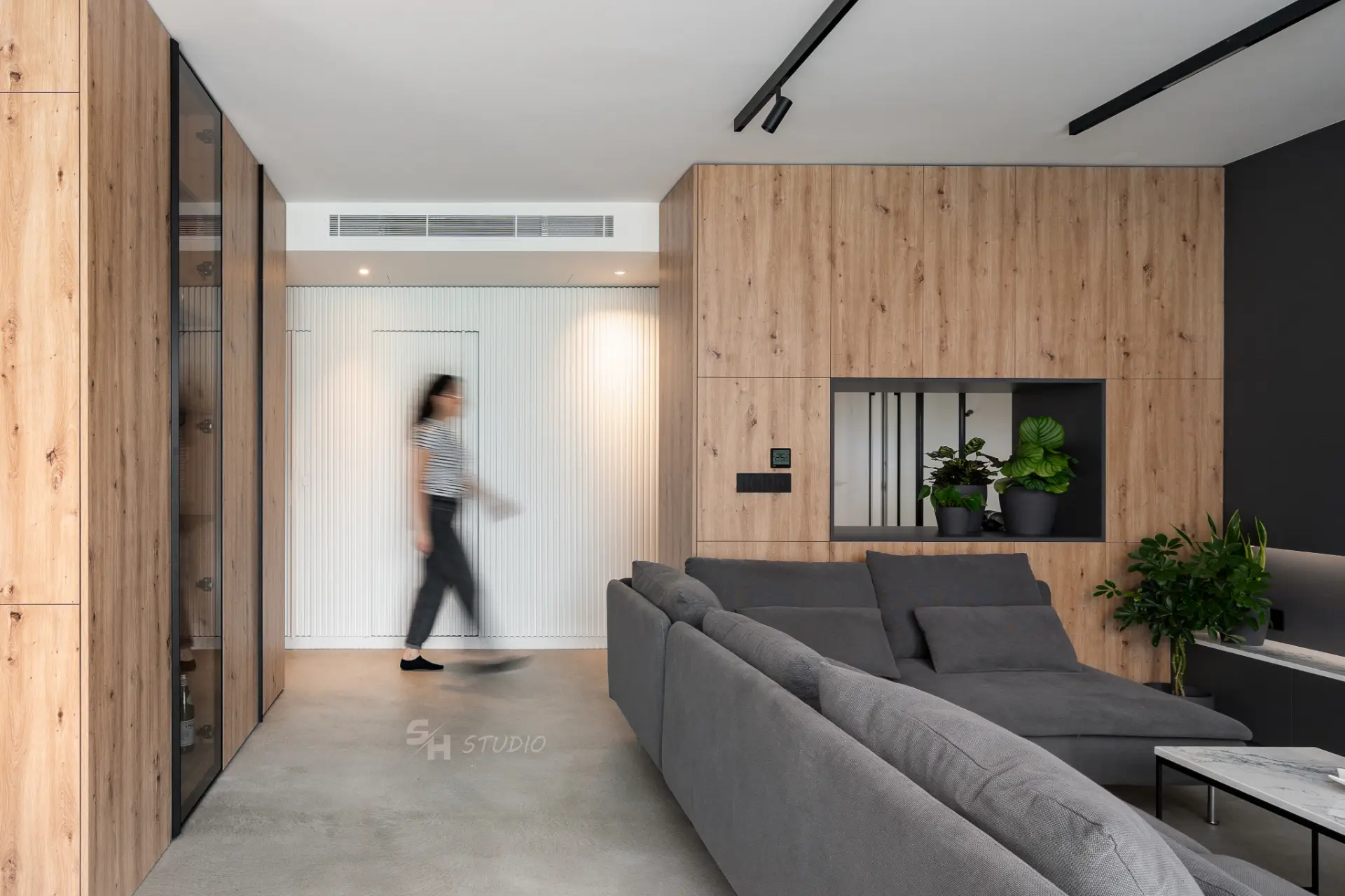PHOBIA — living room viewed towards the fluted entrance wall and timber cabinetry