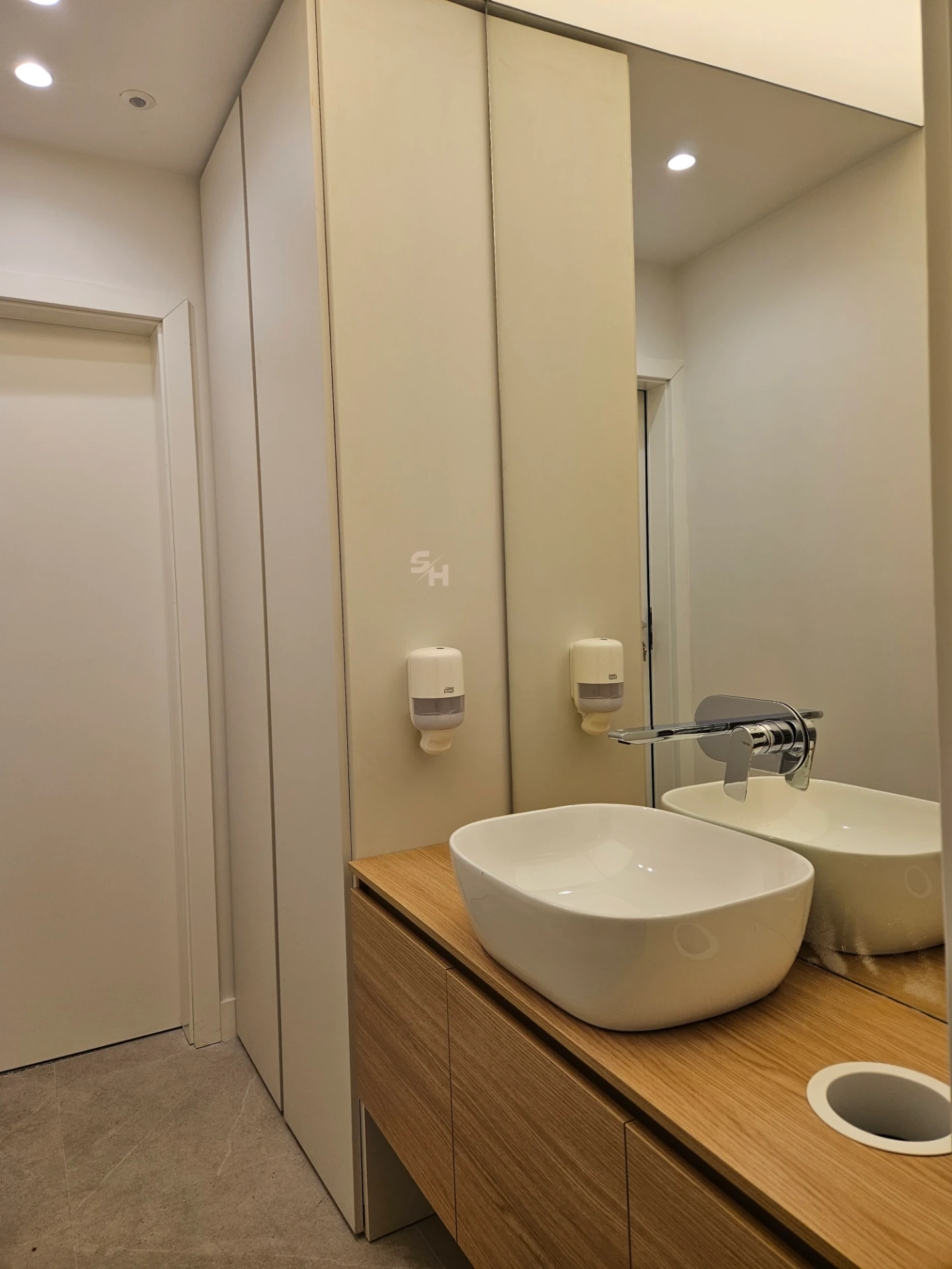 VDR Office — WC lobby with cantilevered waterproof PVC sink counter and mirrored wall