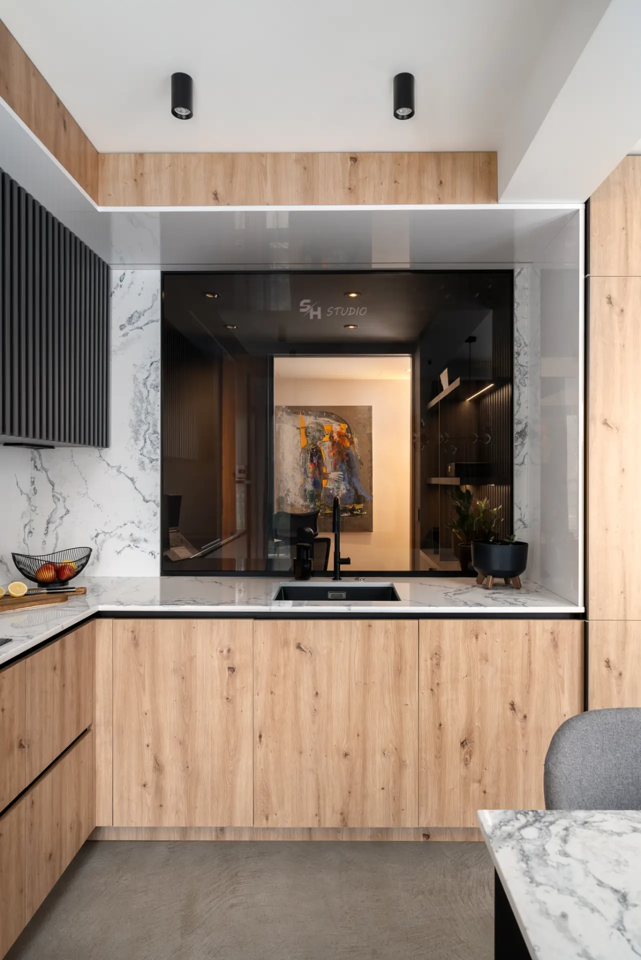 PHOBIA — kitchen sink wall framed by custom cabinetry and stone surfaces