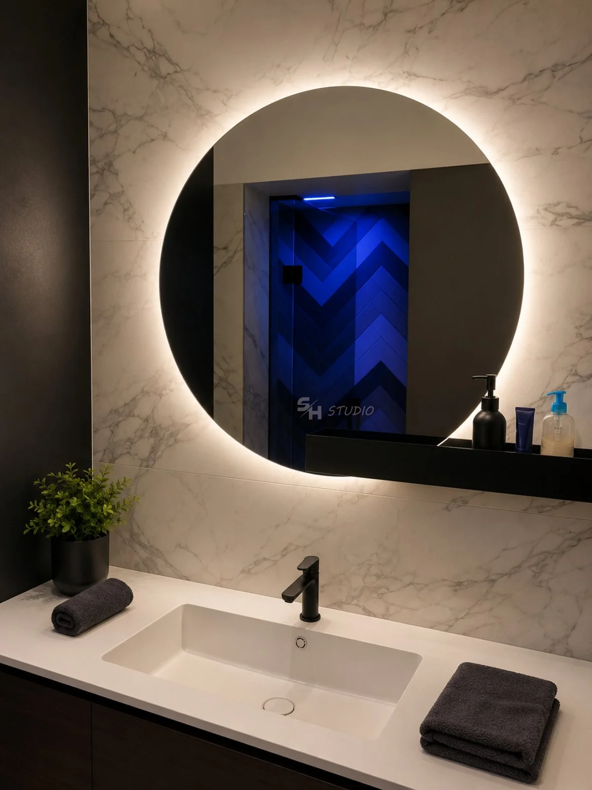 ADVH — Corian basin and round LED-lit mirror in a metal frame