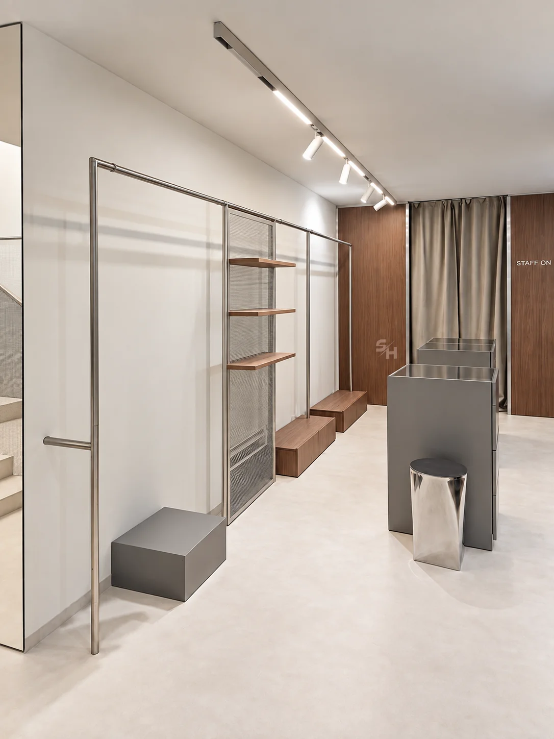 AND menswear store — sales floor with walnut-look wall units, clothing rails and display plinths