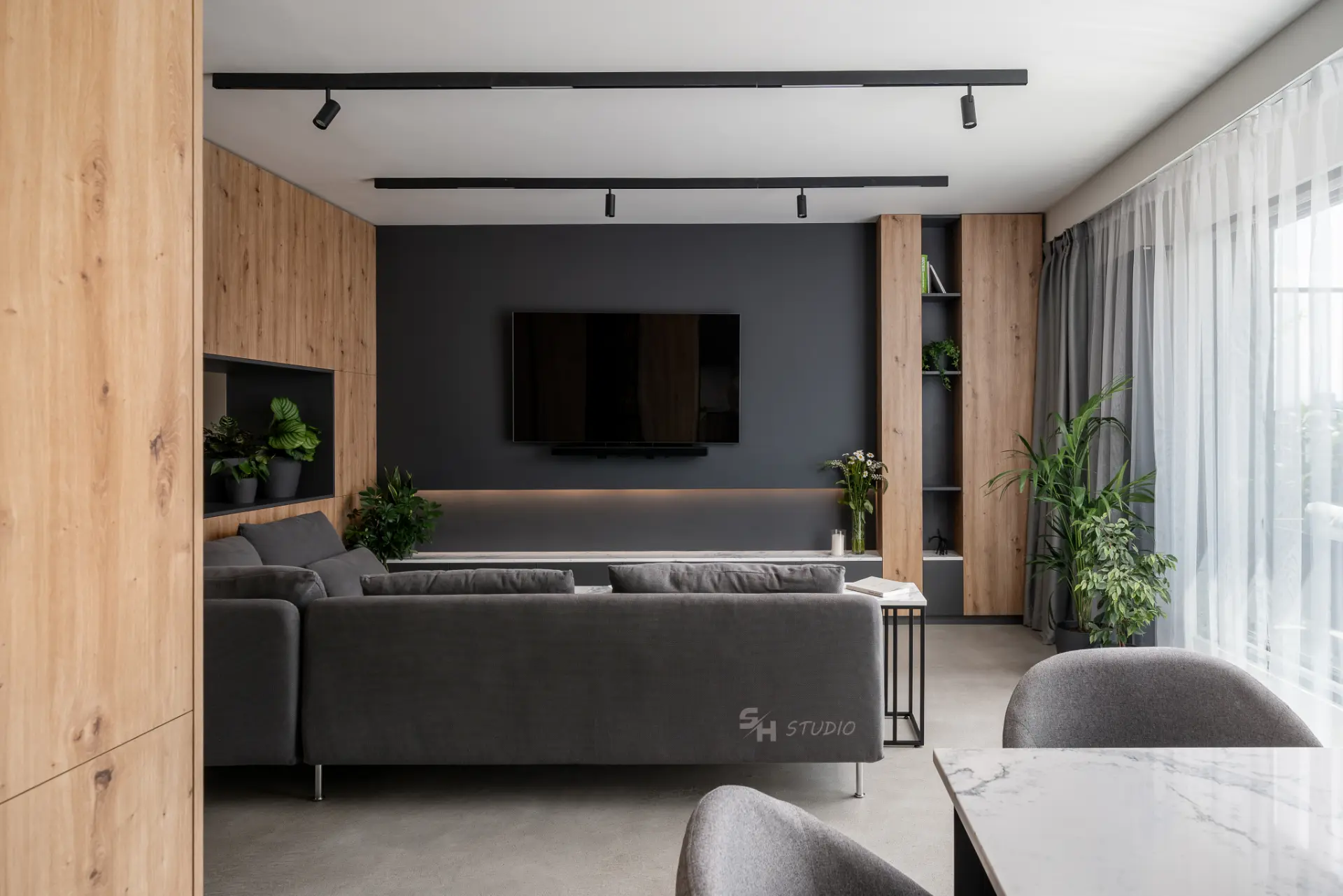 PHOBIA — open-plan living room with a custom timber and charcoal media wall