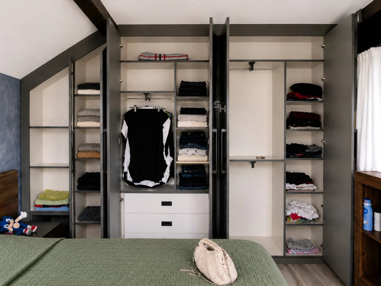 KAI — open built-in wardrobe beneath the sloped ceiling