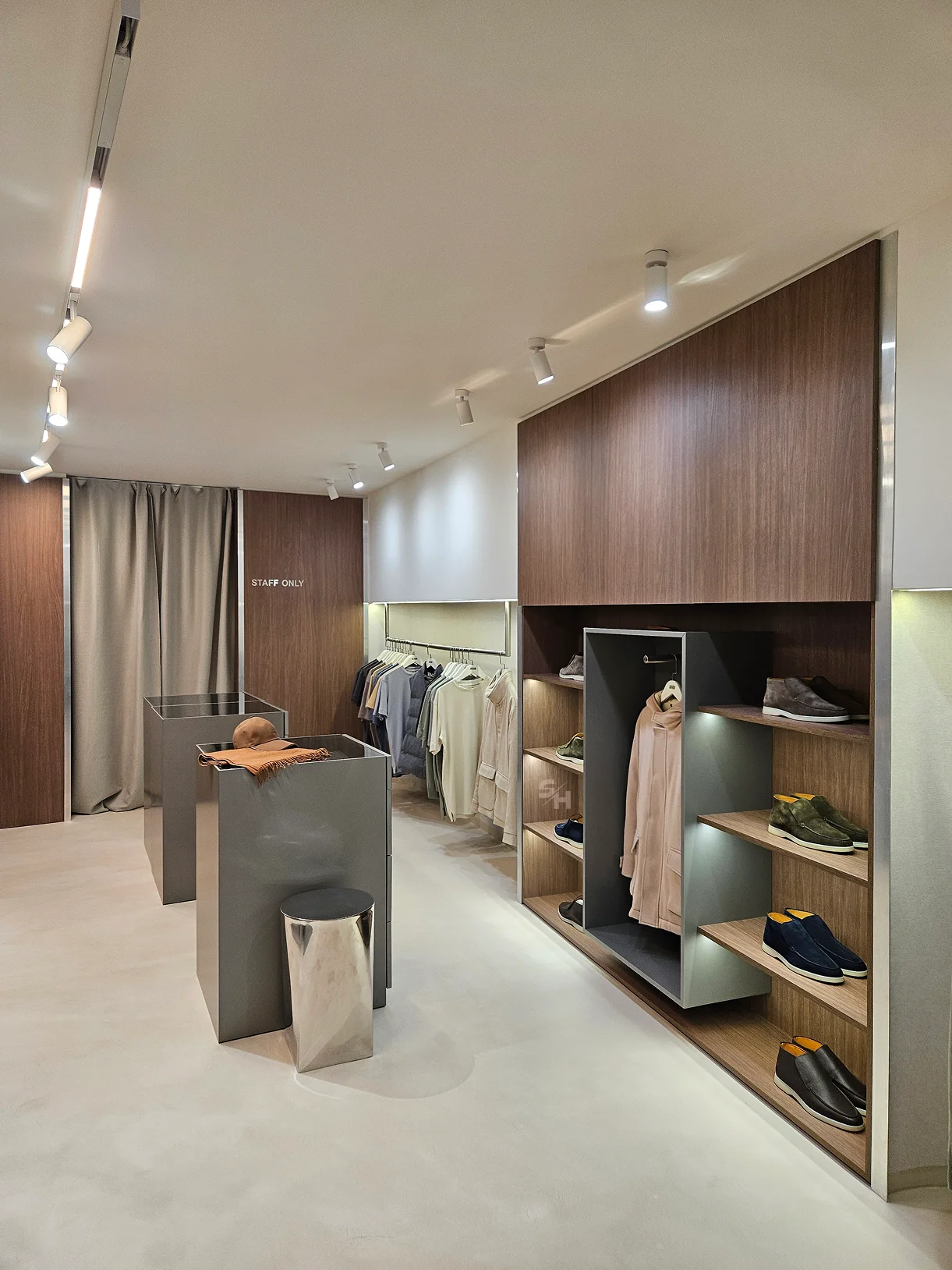 AND menswear store — sales floor with walnut-look wall units, clothing rails and display plinths