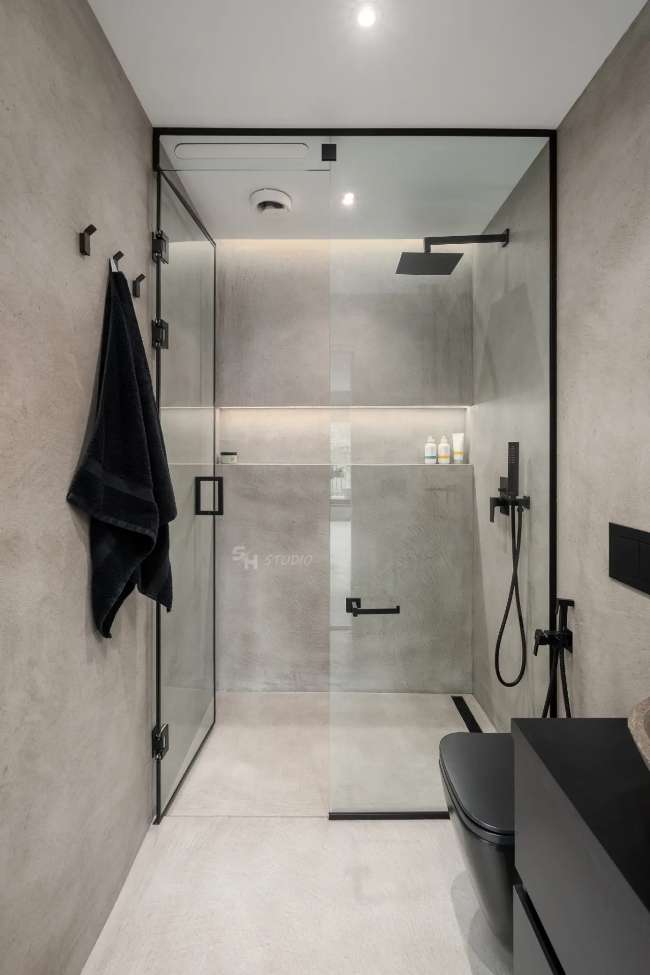 PHOBIA — glazed walk-in shower with black fittings and an illuminated wall niche